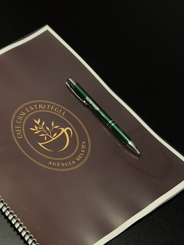 Caderno personalizado do Café com Estratégia com caneta verde por cima